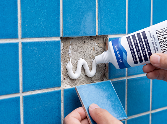 Applying adhesive behind a replacement pool tile